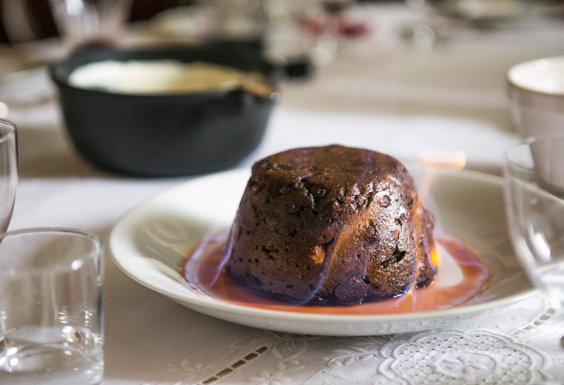 Close up on a Christmas pudding on fire on a table top. 