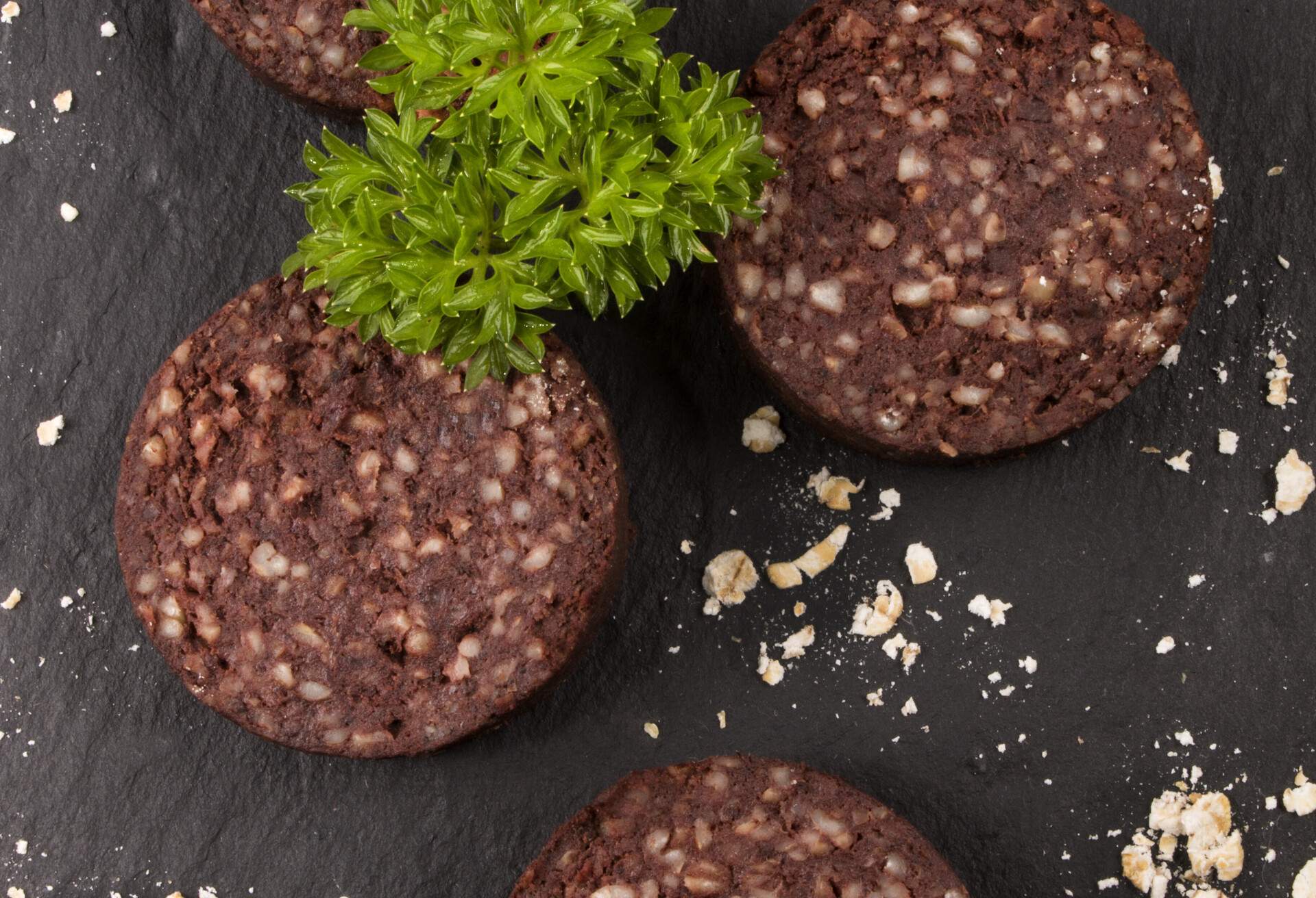 raw irish black pudding with oatmeal and parsley on slate