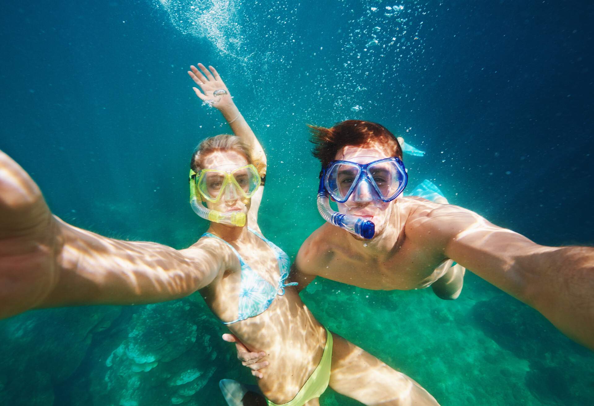 Shot of a young couple snorkelling in crystal clear water 