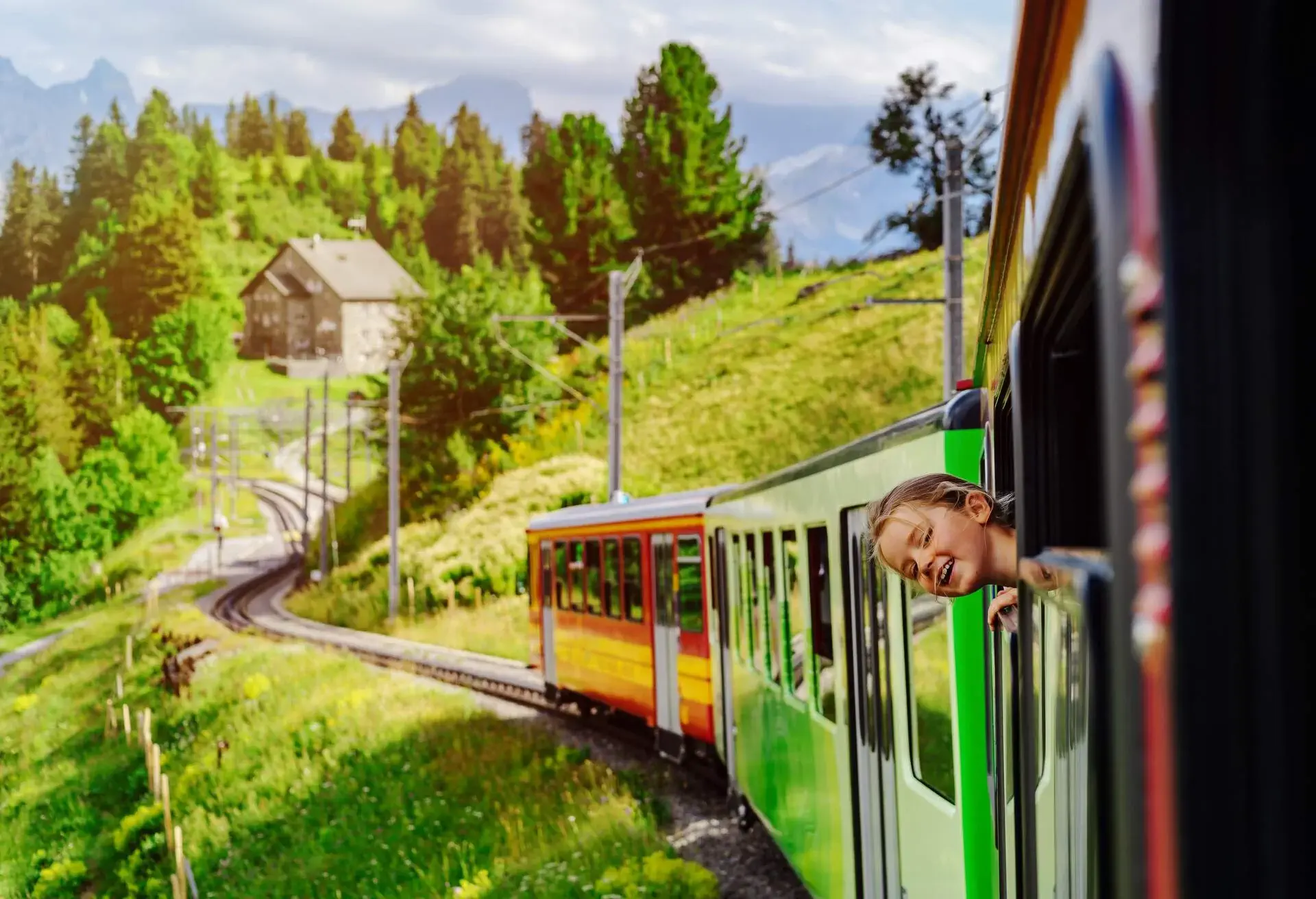 Little girl looking through the window of alpine train