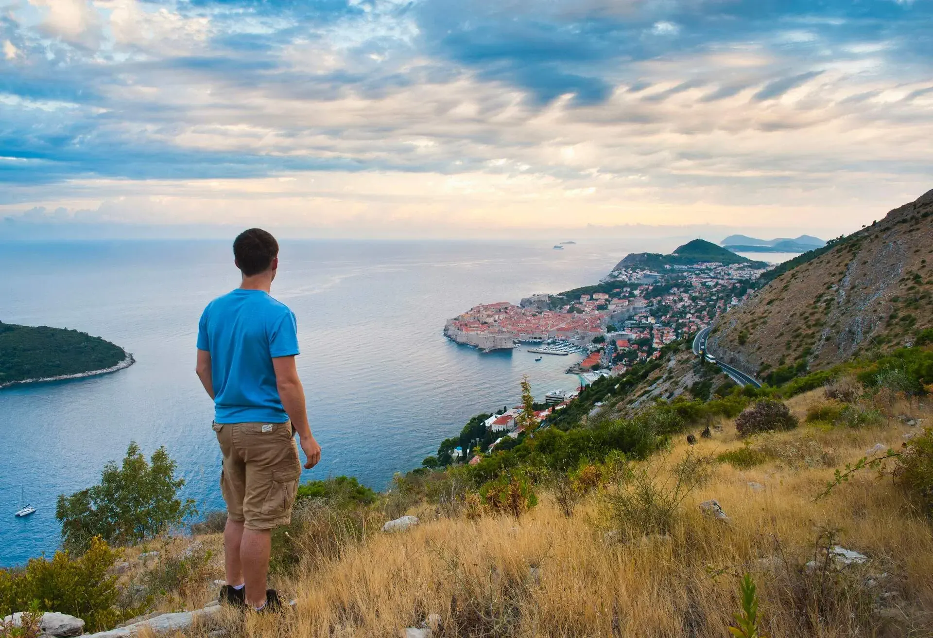 Dubrovnik Old Town at sunrise, a tourist admiring the view from Zarkovica Hill, Dalmatian Coast, Croatia