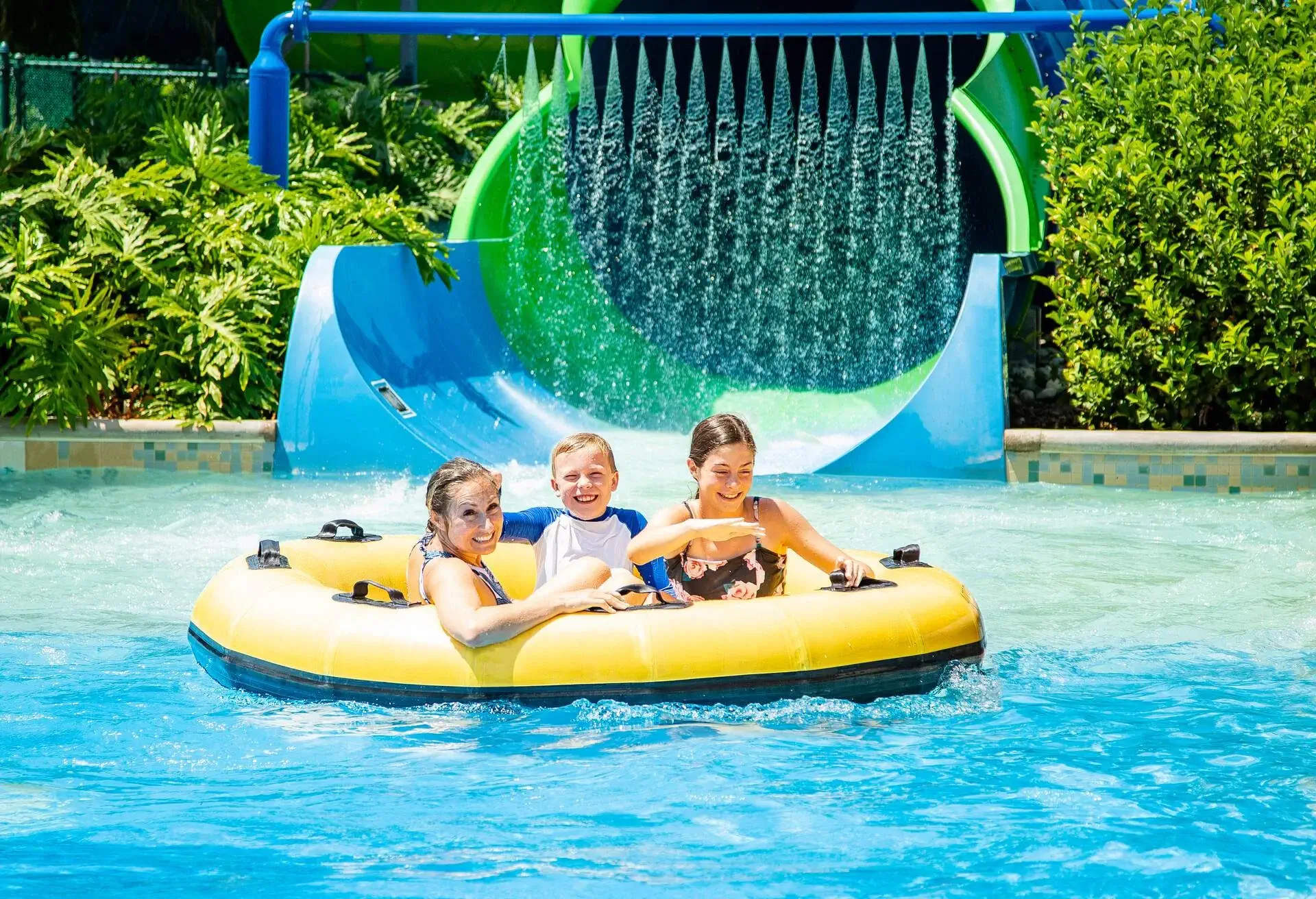 Family having fun together a water park. Riding on an inflatable tube together on a water slide.; Shutterstock ID 1523161307