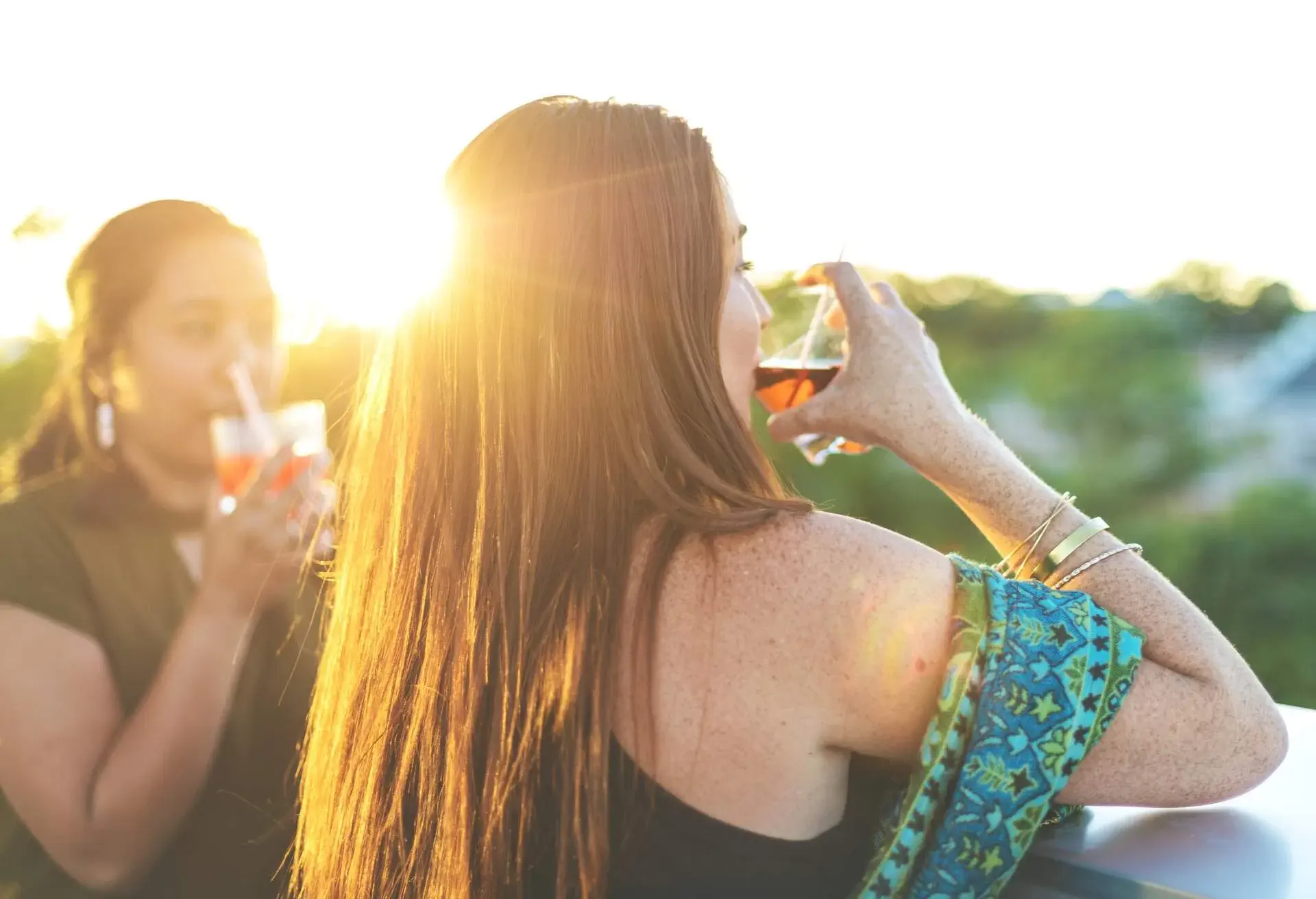 Beautiful Millennial Females At Sunset Enjoying and Urban Environment with Cocktails Containing Rum on a Patio Overlooking the City at Golden Hour (Shot with Canon 5DS 50.6mp photos professionally retouched - Lightroom / Photoshop - original size 5792 x 8688)
