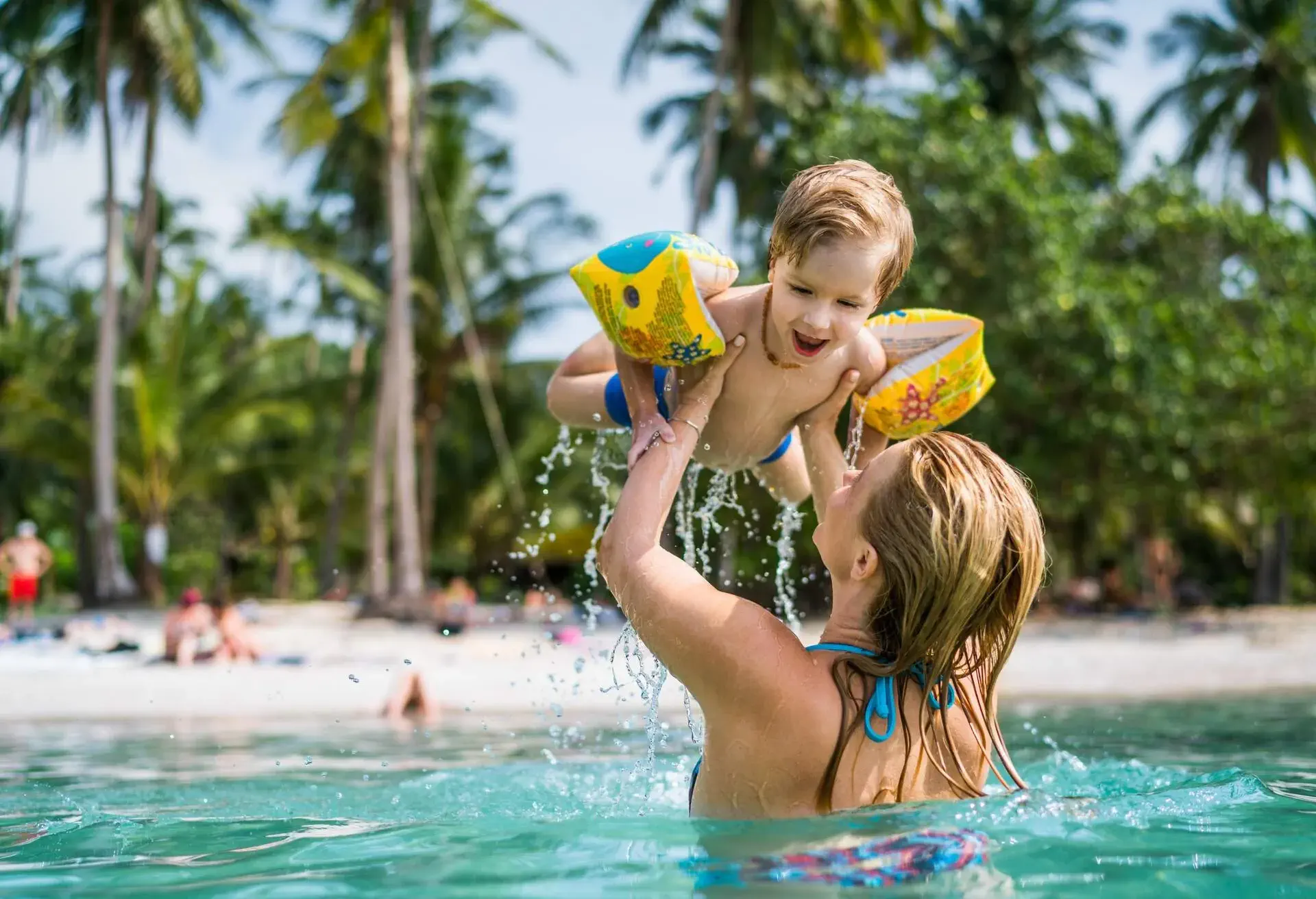 Cute kid having fun with his mother in the sea.