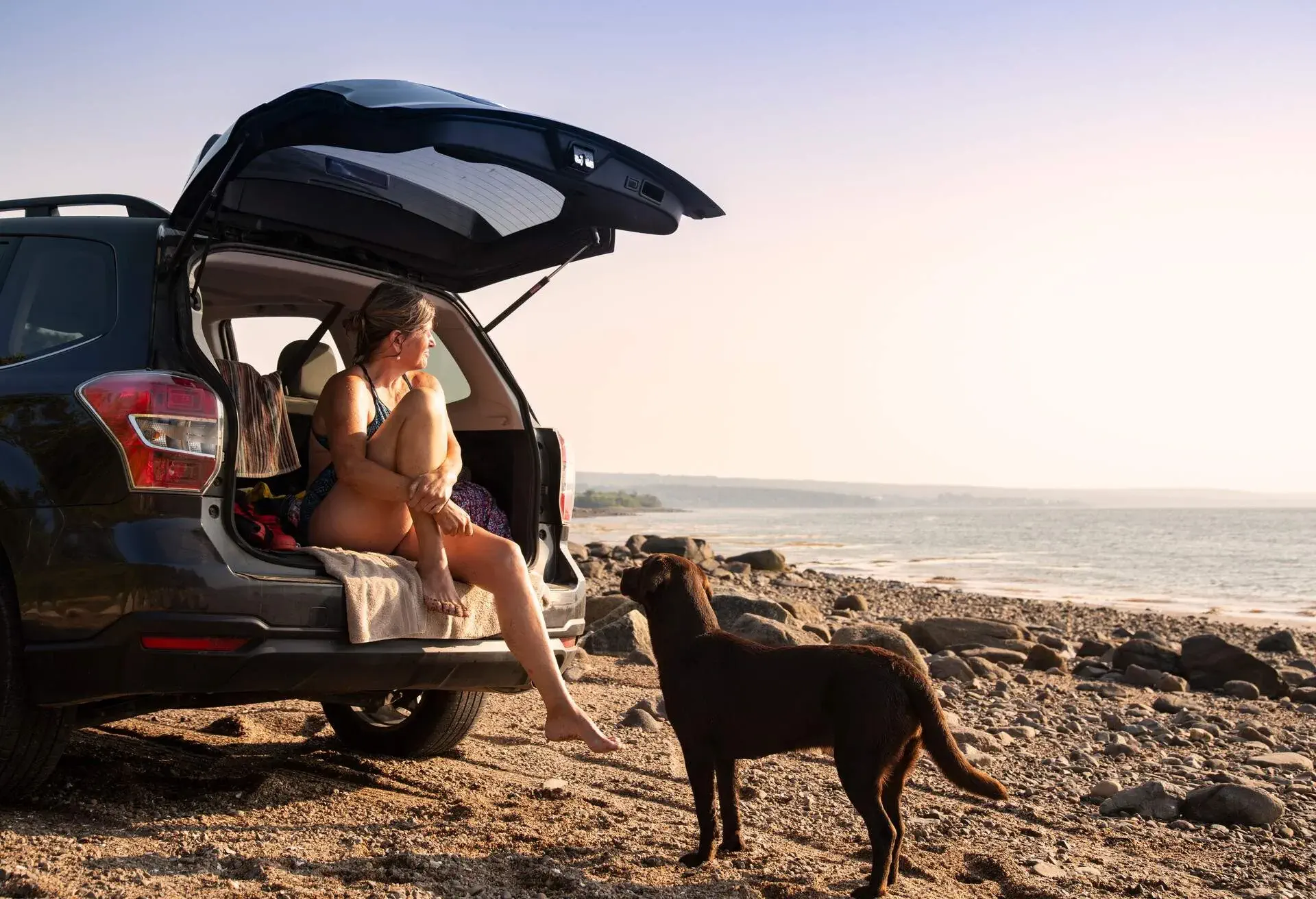 A mature woman and her Labrador puppy on the beachLabradorpuppy
