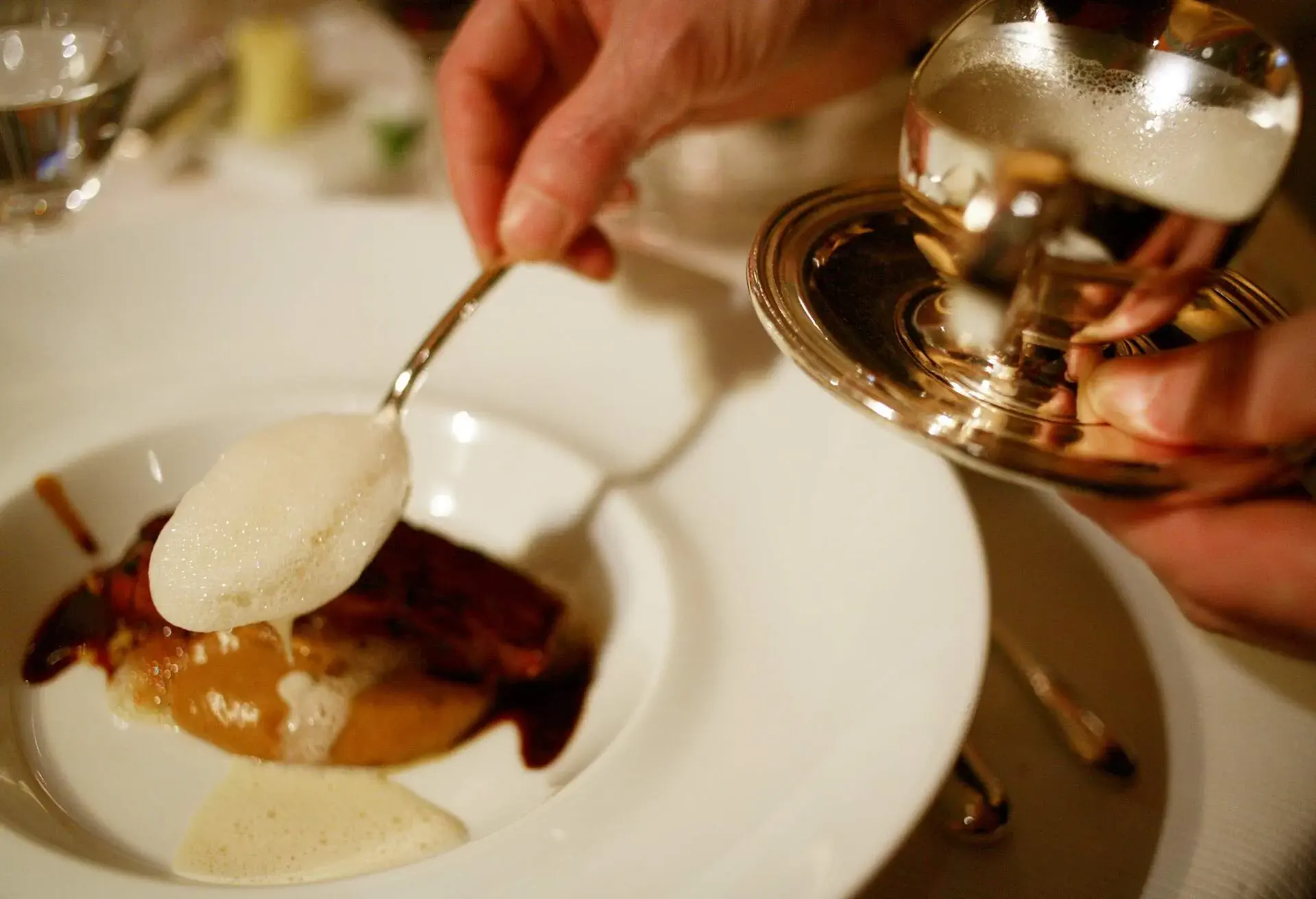 Waiter saucing a dish at Michelin Three Star Restaurant Pierre Gagnaire, Paris