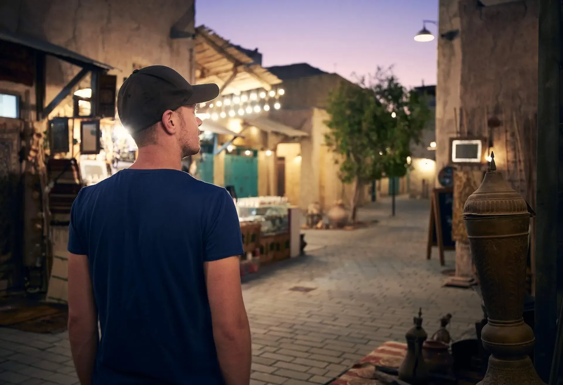 Rear view of young man walking through traditional Dubai souk, United Arab Emirates