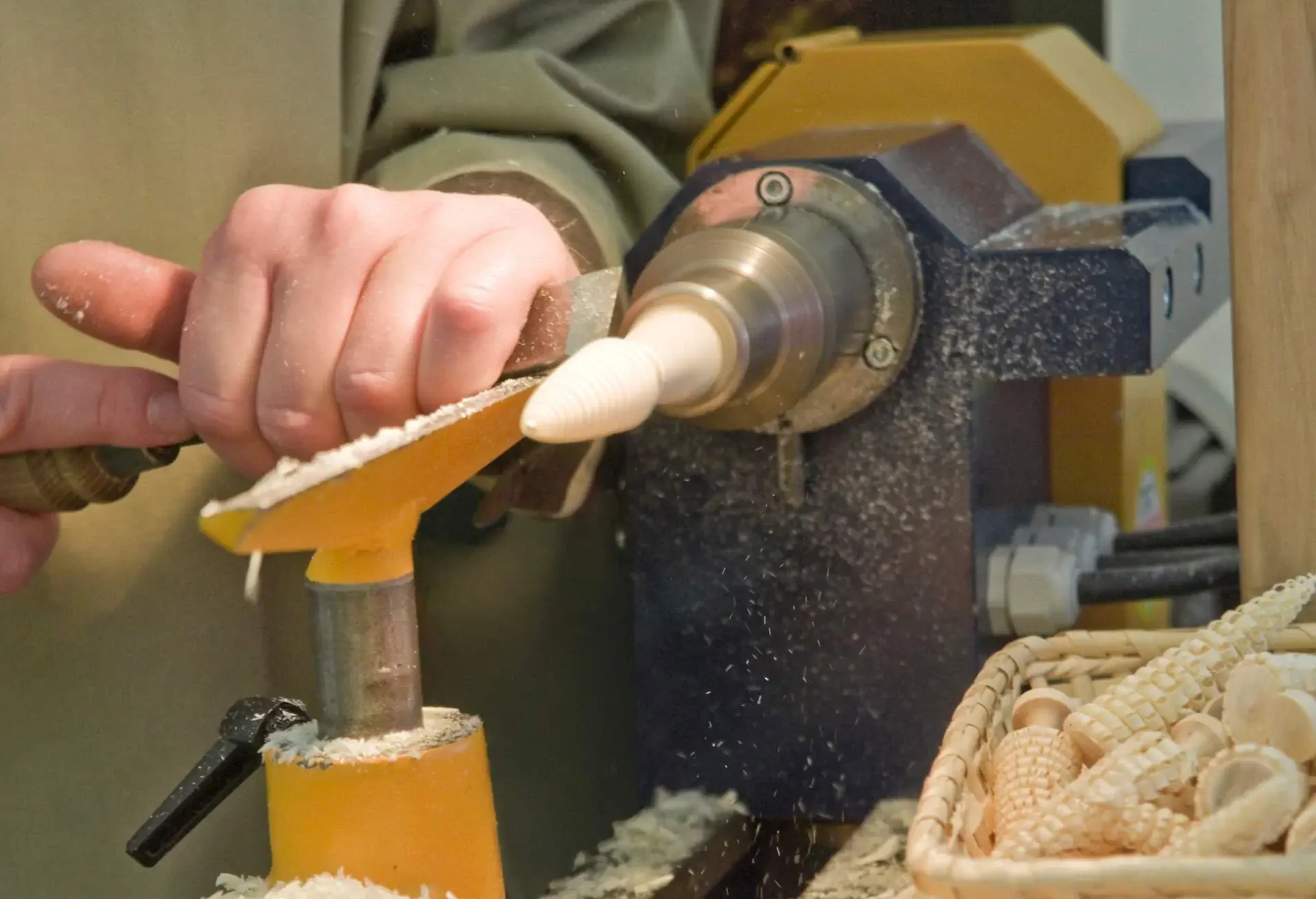 Wood turner manufactures small wood trees at the turning lathe. Ore Mountain folk art in Saxony, Germany.