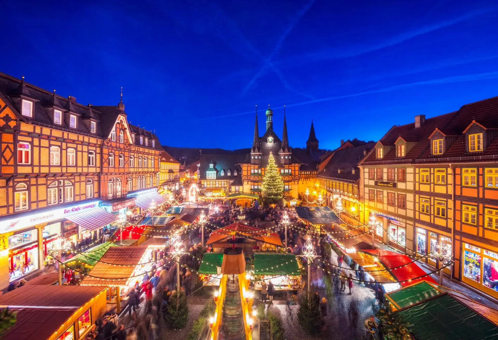 View over the town square with it´s beautiful medieval half-timbered houses and christmas market on the illuminated landmark town hall of Wernigerode.