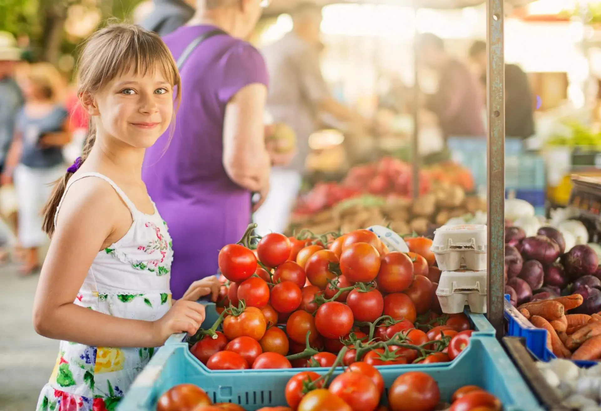 Happy little girl buying local groceries food at the farmer's market at Majorca.