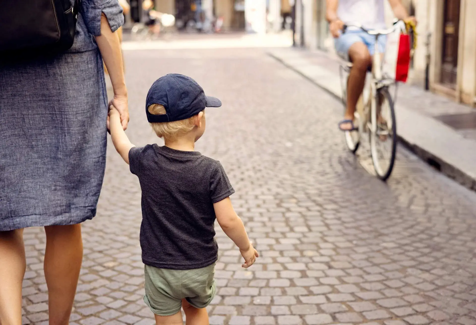 Mother walking hand in hand with her little son