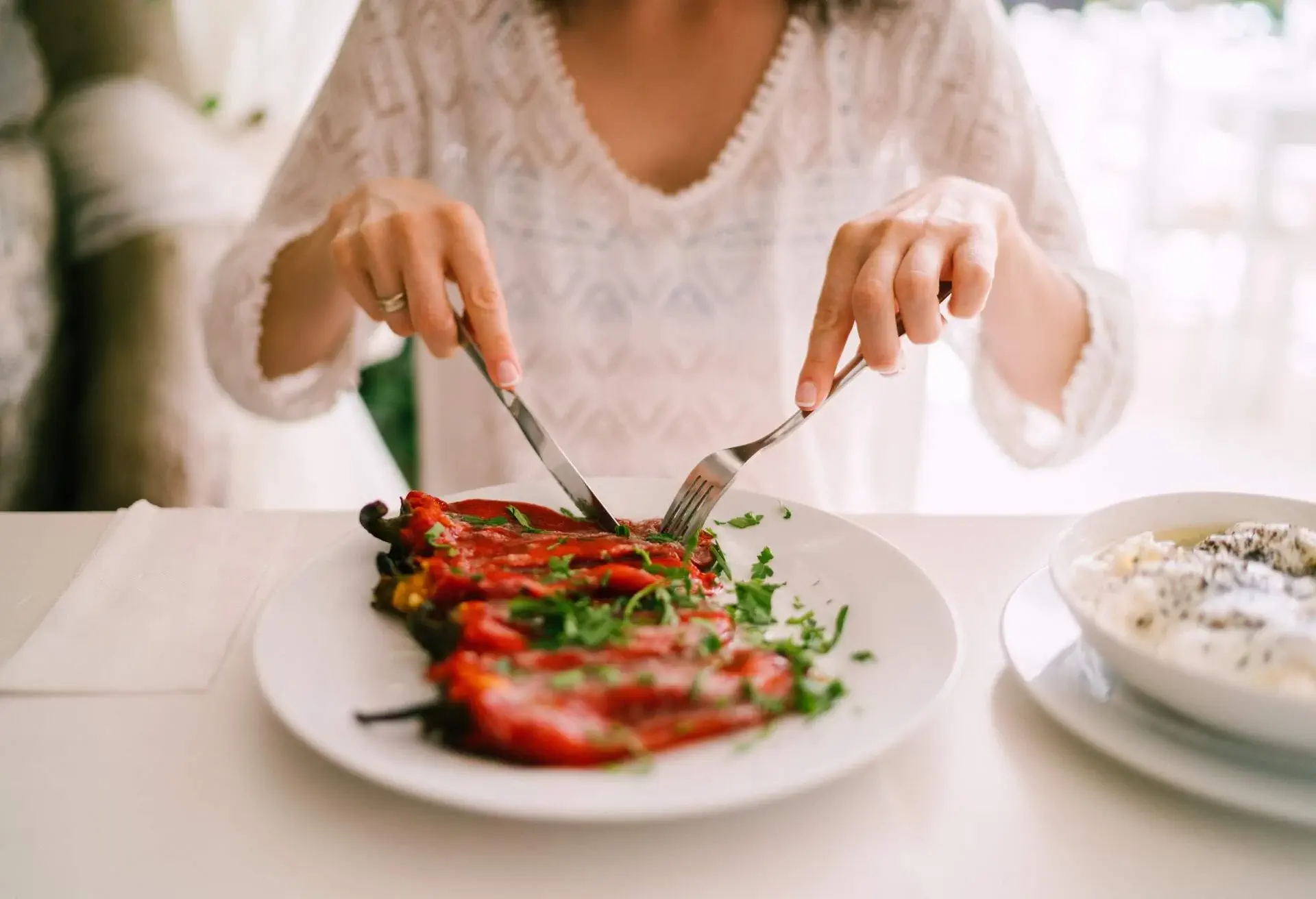Close-up of woman eating salad of red peppers