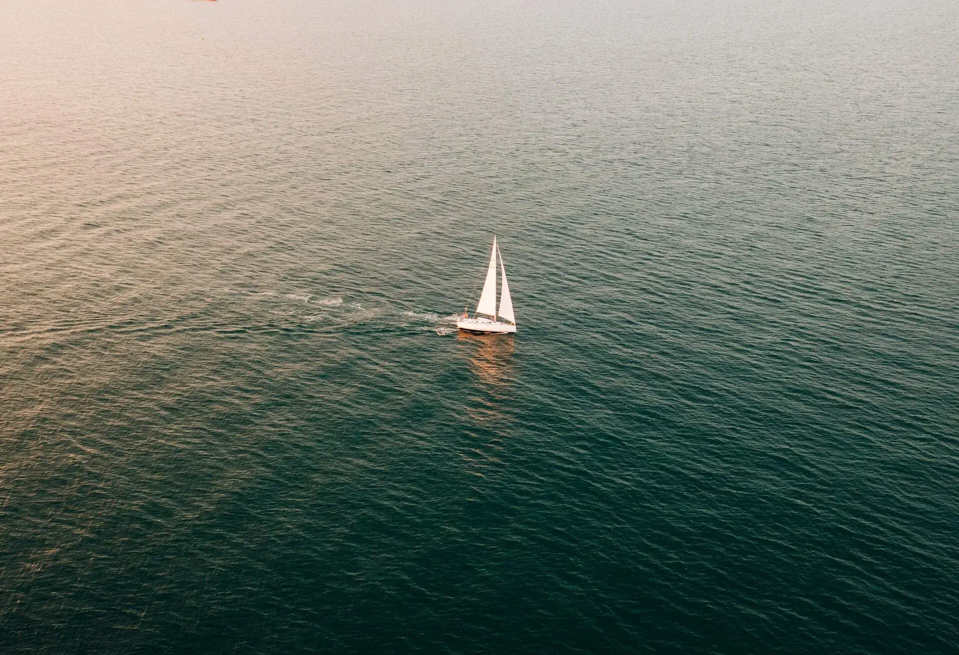A yacht sailing on The Solent sea on a sunny evening